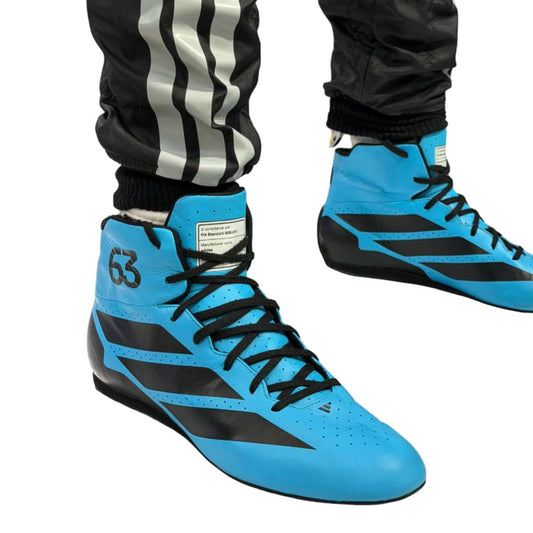 2026 George Russell Racing Shoes Replica: a pair of high-top athletic shoes in bright blue and black, shown on a person wearing black track pants with white stripes.