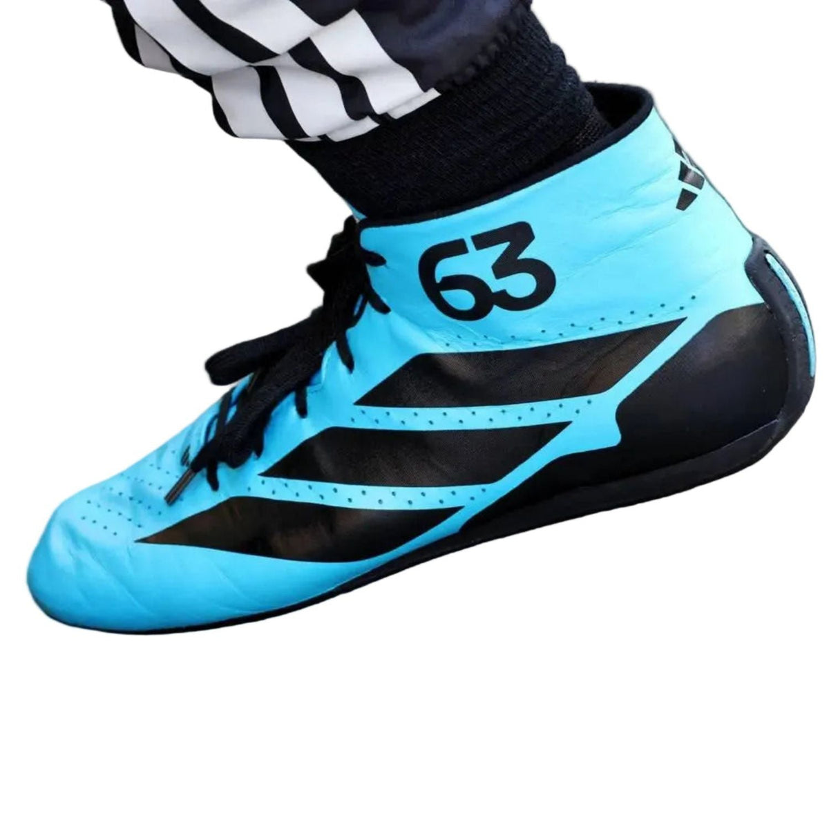 2026 George Russell Racing Shoes Replica: a light blue and black athletic shoe shown on a person's foot, with black-and-white striped socks visible above it. The shoe has black laces, black three-stripe style accents, and the number 63 printed in black on the side.