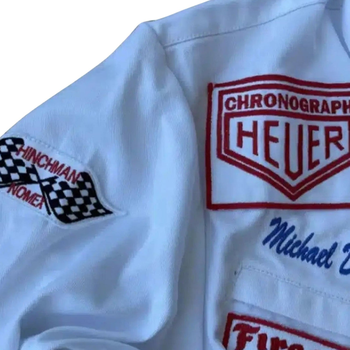 1971 Michael Delaney Racing Suit – F1 The Movie Replica: close-up of a white Michael Delaney 1971 F1 The LeMans Movie Race Costume PorscheGulf (Steve McQueen) with embroidered logos and text.