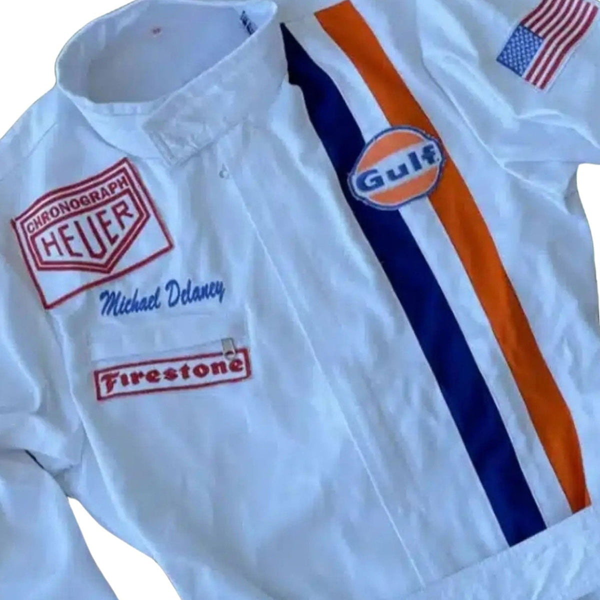 1971 Michael Delaney Racing Suit – F1 The Movie Replica: white Michael Delaney 1971 F1 The LeMans Movie Race Costume Porsche Gulf (Steve McQueen) with Gulf, Heuer, and Firestone logos close up.