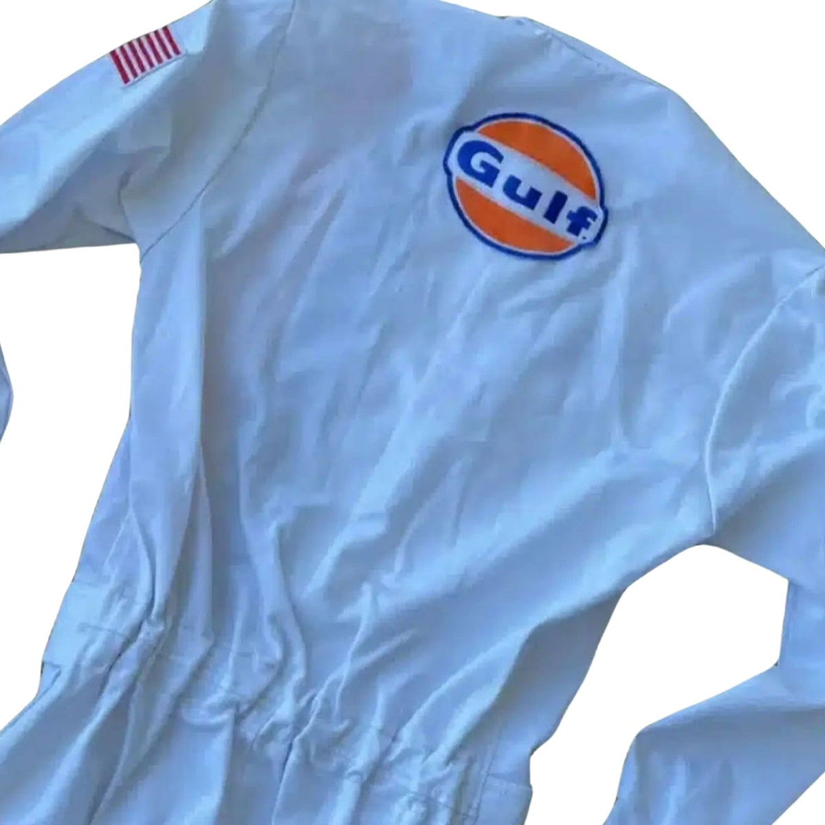 1971 Michael Delaney Racing Suit – F1 The Movie Replica: a light blue Michael Delaney 1971 F1 The LeMans Movie Race Costume Porsche Gulf (Steve McQueen) with a large embroidered Gulf logo on the left chest and a small red-and-white striped flag patch on the right sleeve.