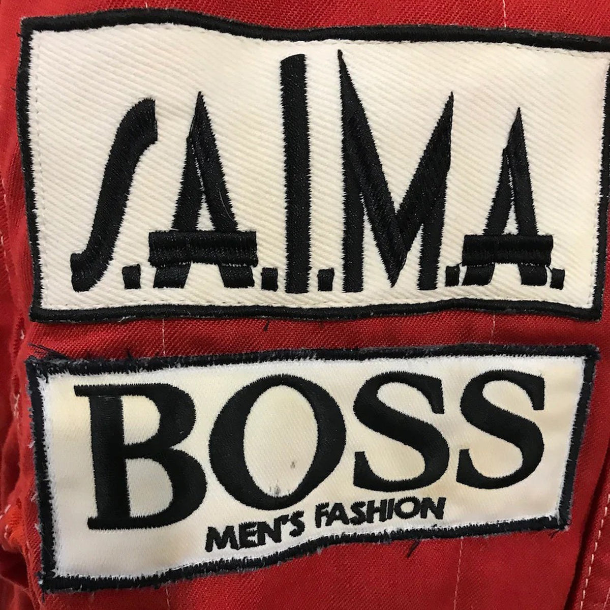 Niki Lauda Racing Suit Replica 1984: niki Lauda 1984 F1 Race Costume Replica McLaren World Championship Winning Season Two patches on a red background, one with 'S.A.I.M.A.' and the other with 'BOSS Men's Fashion'.