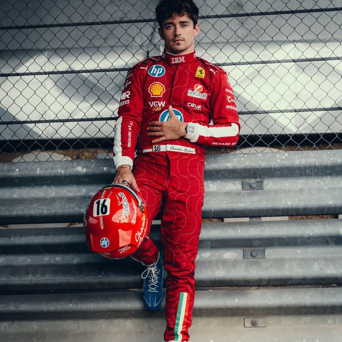 2025 Racing Suit Replica – Charles Leclerc Monza GP: charles Leclerc 2025 F1 Race Costume Ferrari Monza GP holding a helmet with a fence in the background.